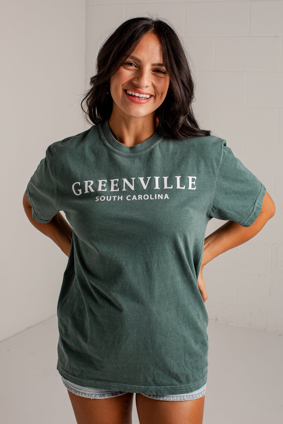 A woman wearing a faded green t-shirt with &