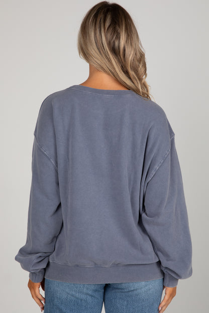 Person wearing a blue sweatshirt and jeans on a plain background