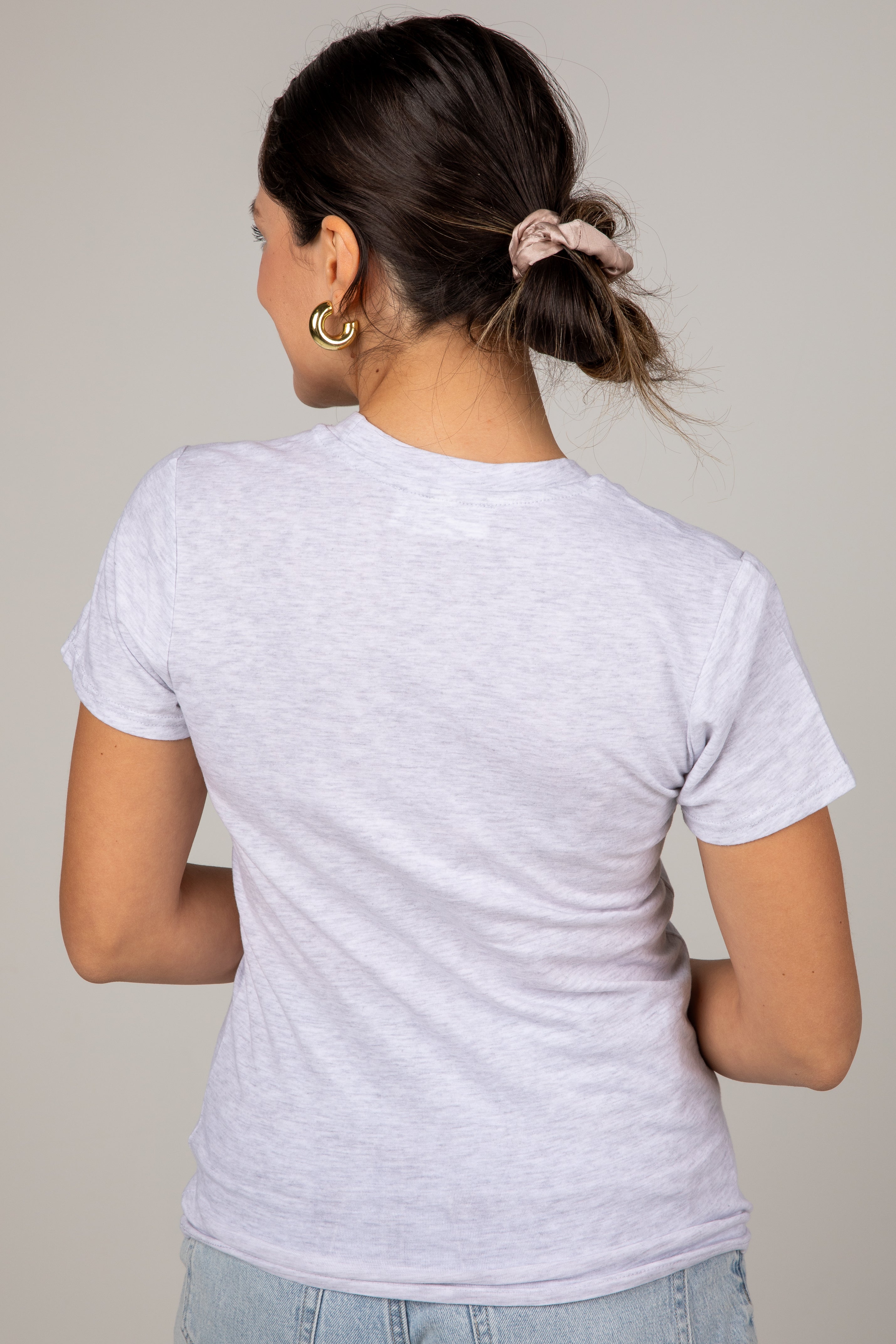 Person wearing a light gray t-shirt against a plain background