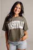 A woman wearing a cropped olive green t-shirt with &