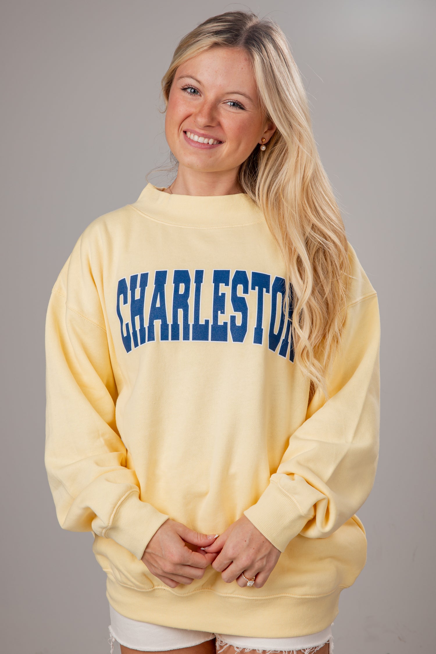 Woman wearing a yellow sweatshirt with &