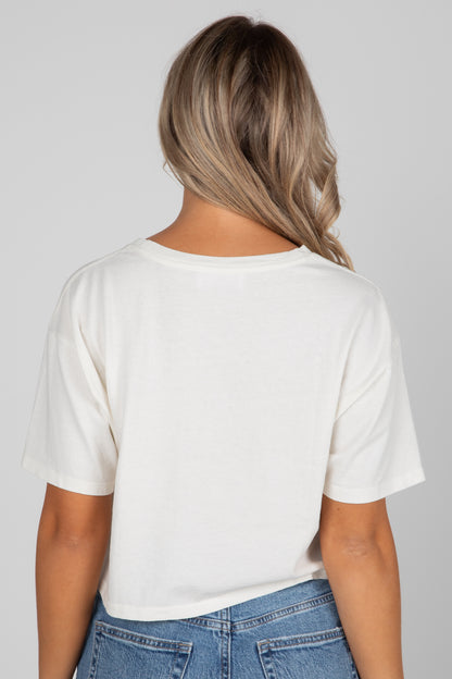 Person wearing a white t-shirt and blue jeans against a plain background