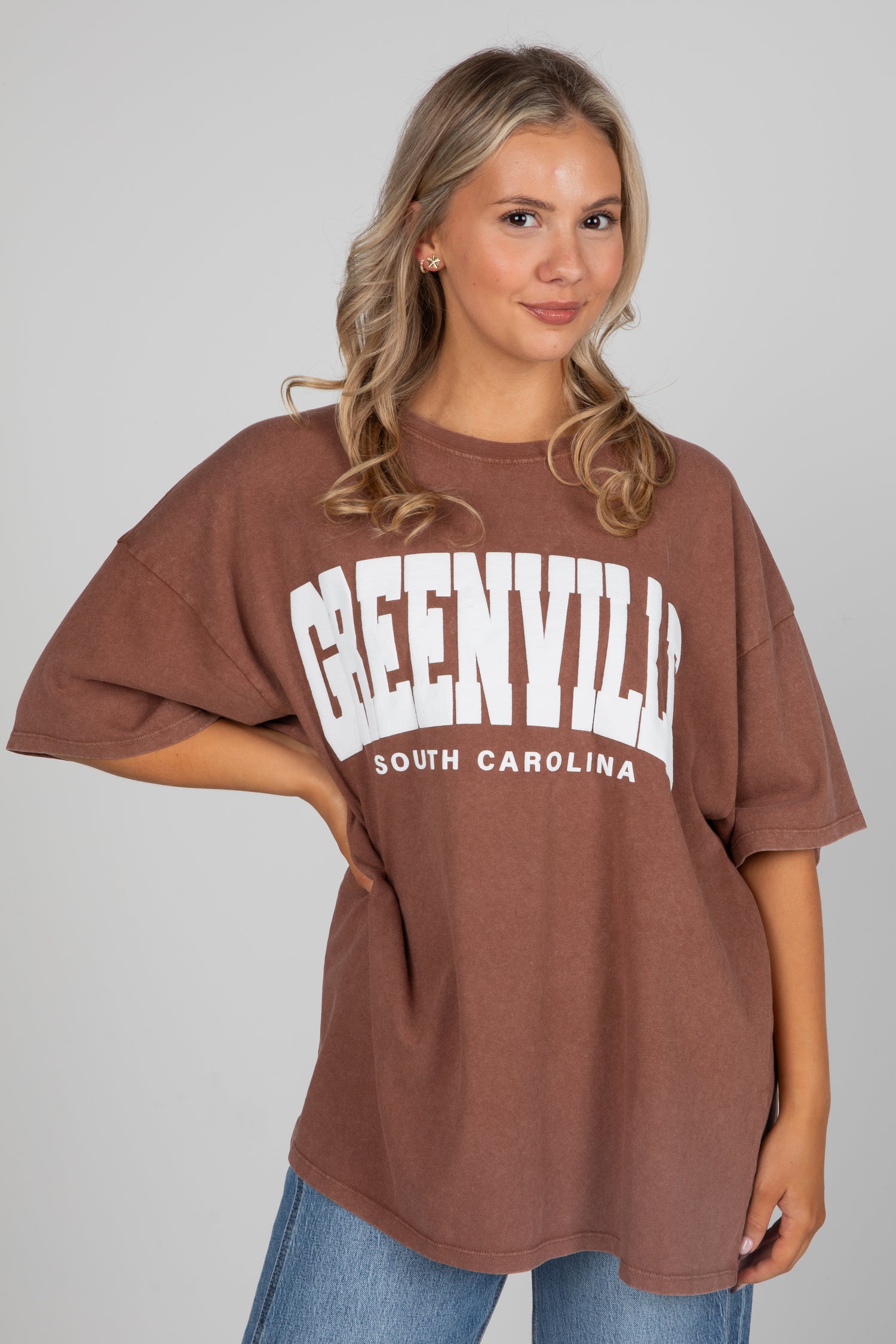 Woman wearing a brown oversized t-shirt with &