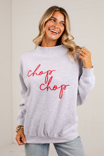 A woman wearing a light heather gray sweatshirt with &