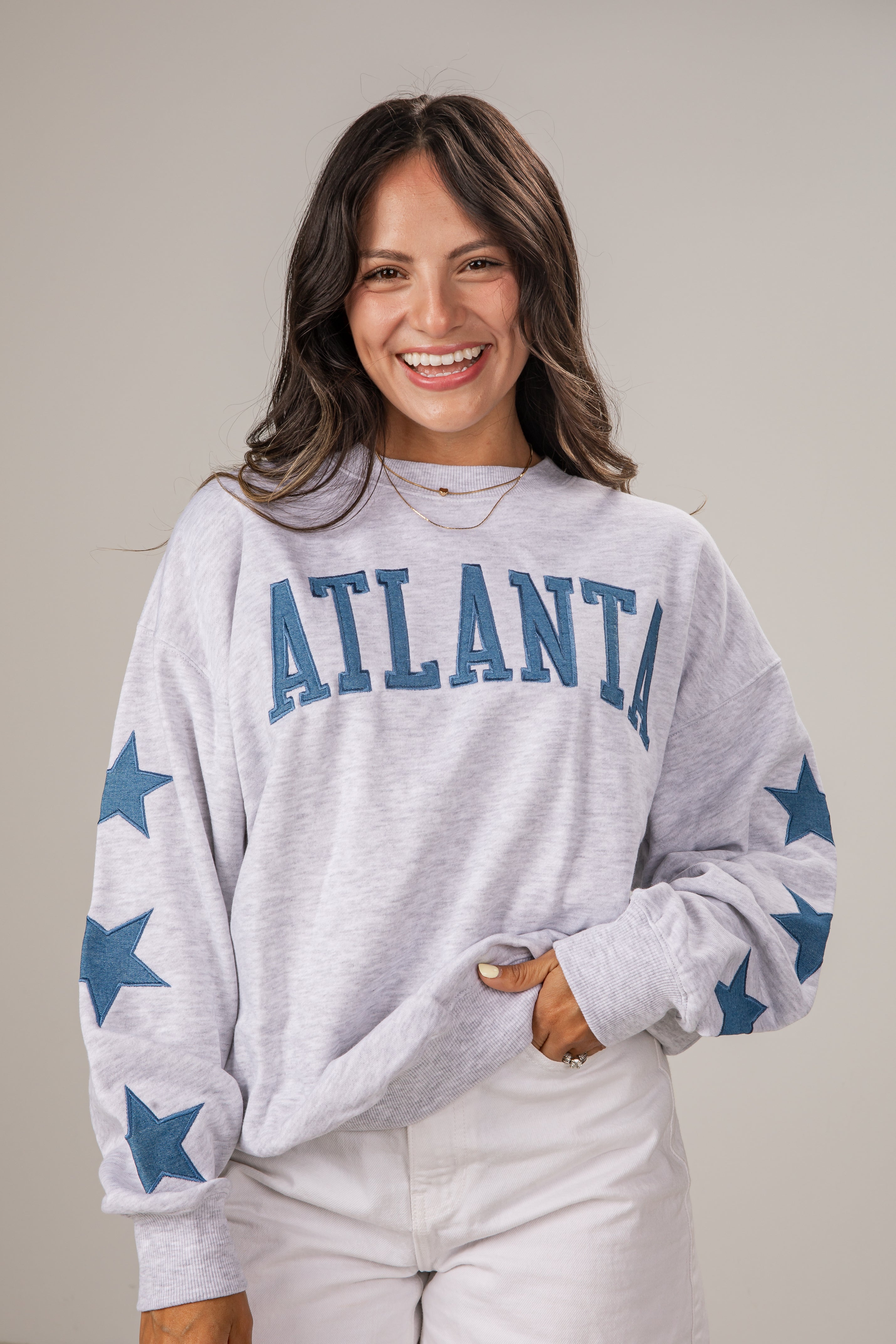 Woman wearing a gray sweatshirt with &