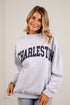 A woman wearing a light heather gray sweatshirt with &