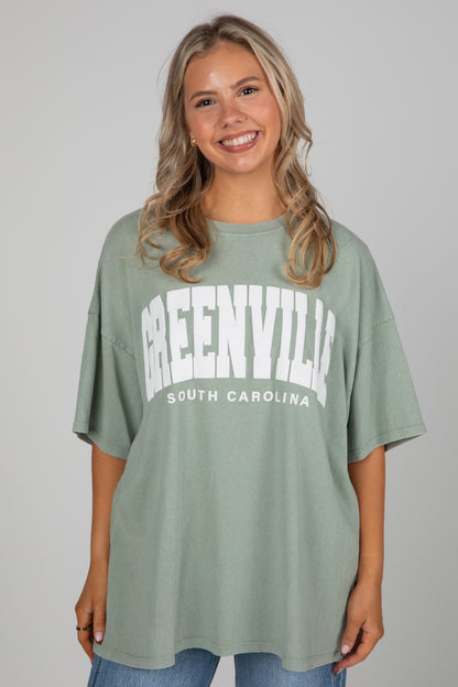 Woman wearing a green t-shirt with &