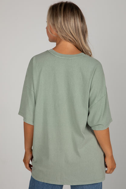 Person wearing a light green t-shirt on a plain background