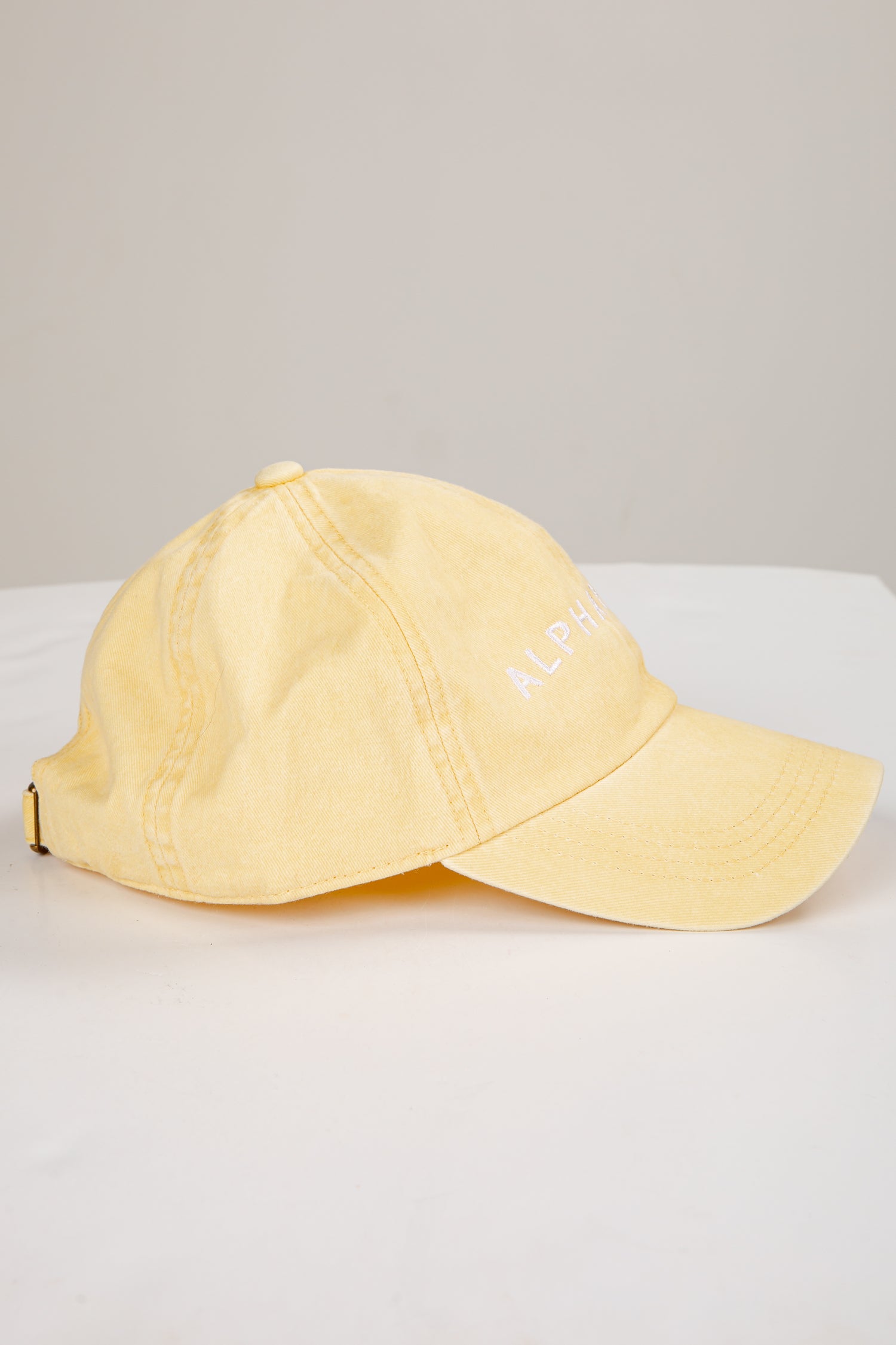 Yellow cap on a white surface with a light gray background
