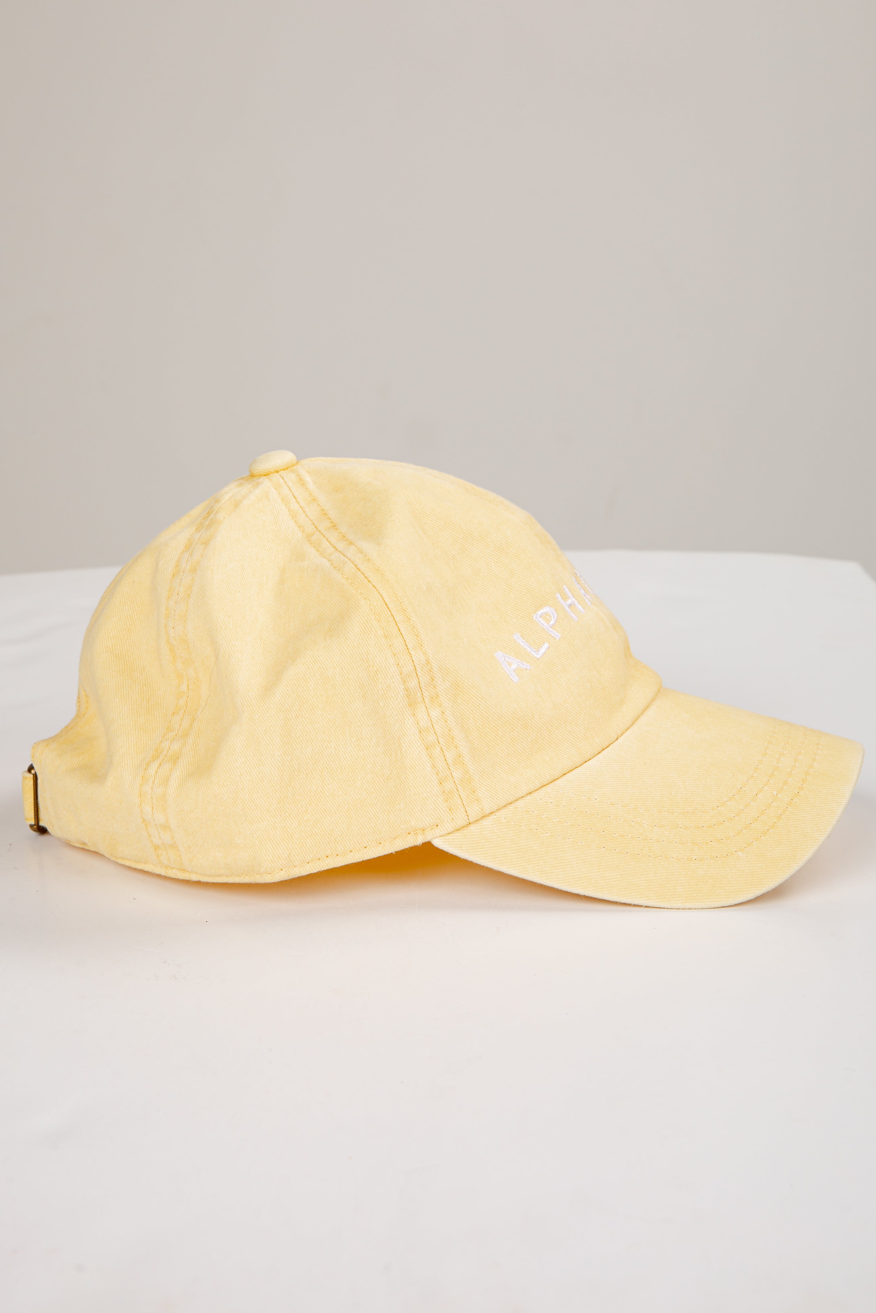 Yellow cap on a white surface with a light gray background