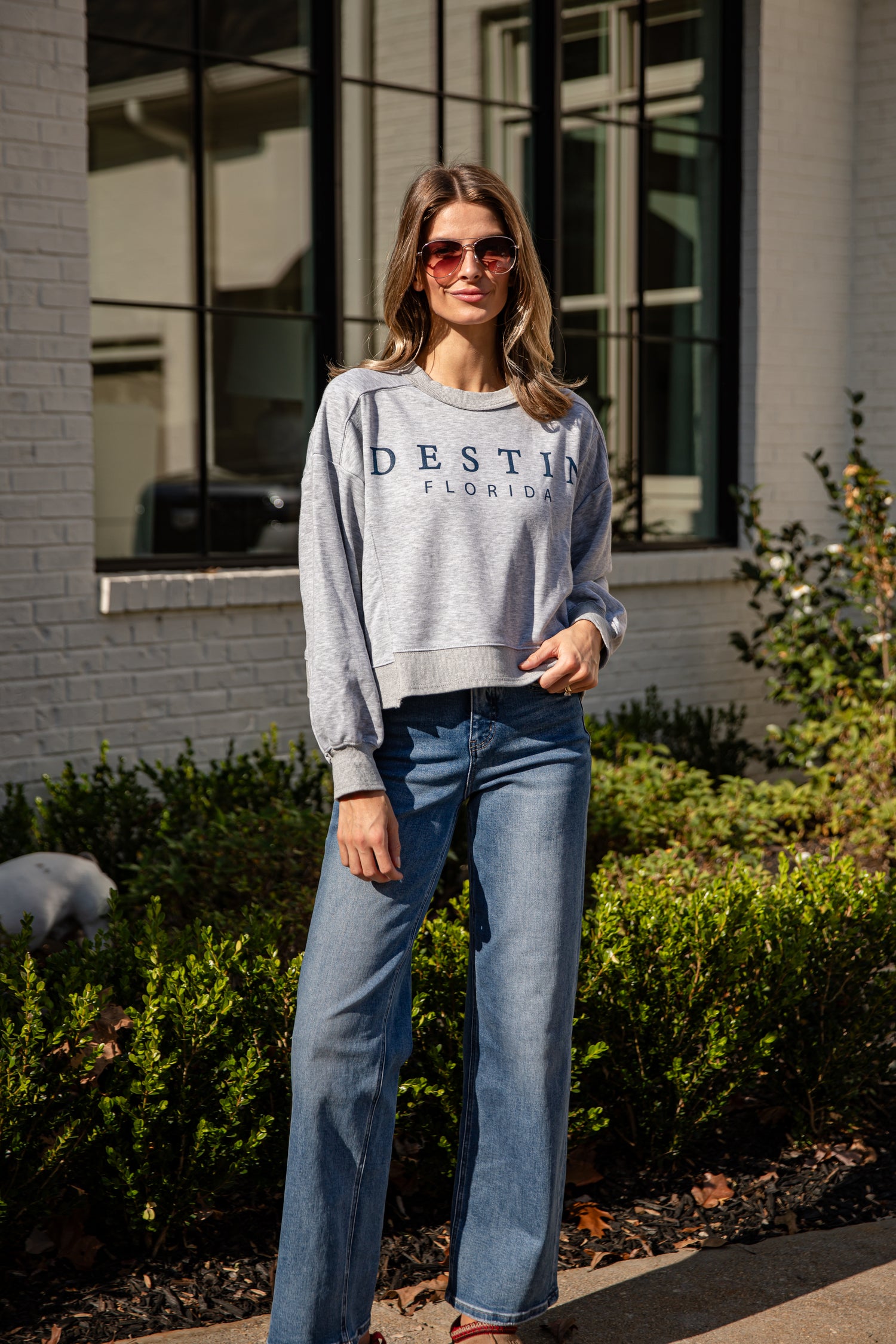 Woman wearing a gray sweatshirt with &