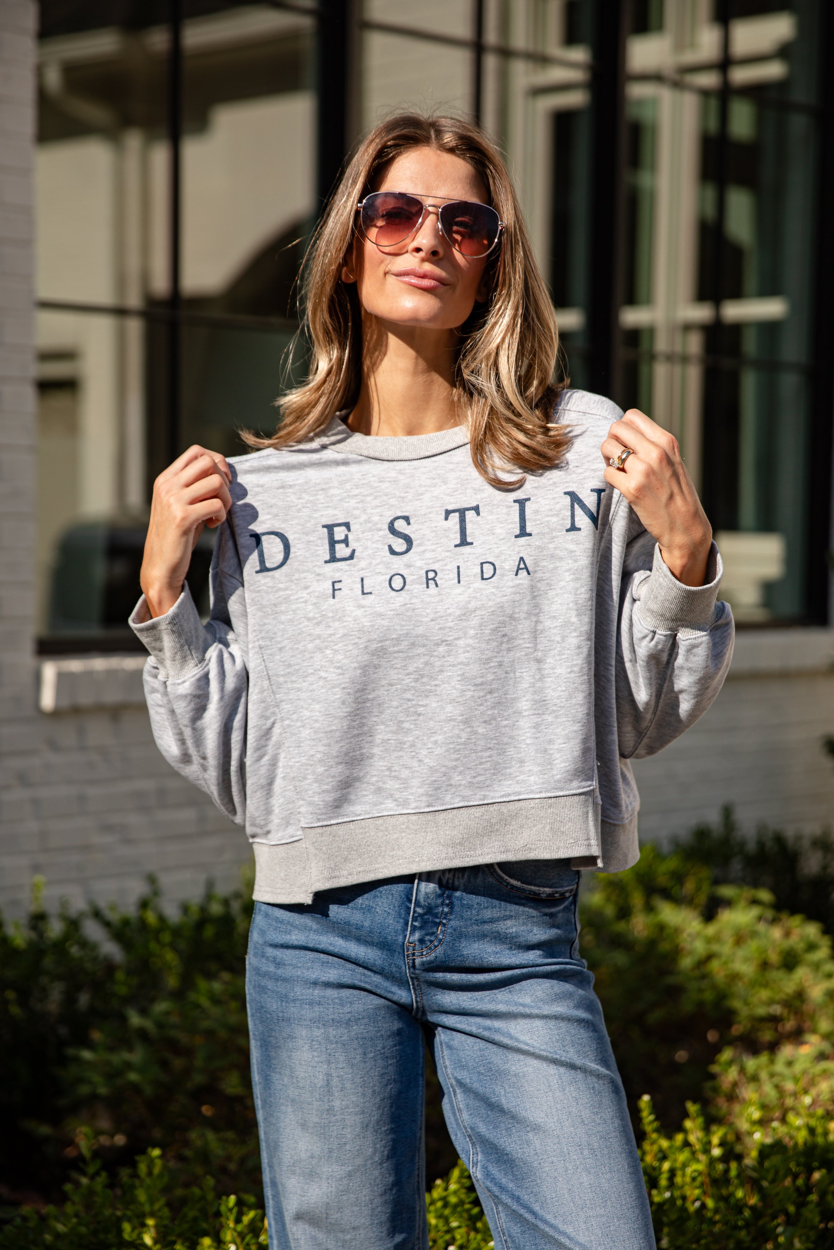 Woman wearing a gray sweatshirt with &