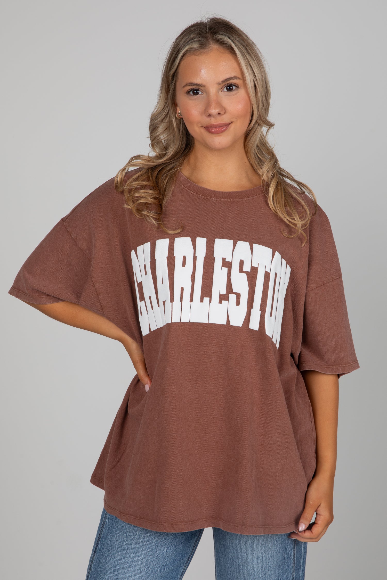 Woman wearing a brown oversized t-shirt with &