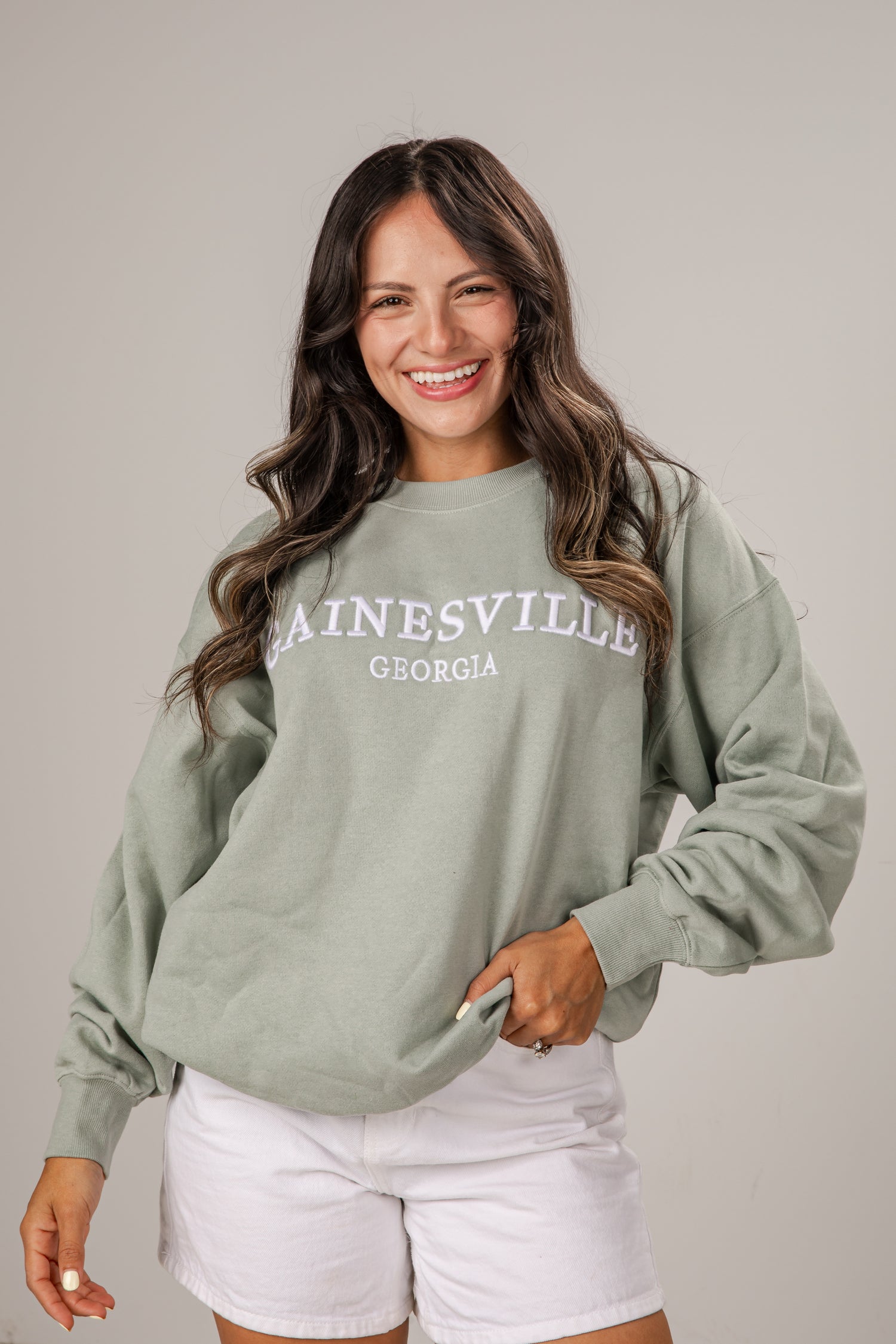 Woman wearing a green sweatshirt with &