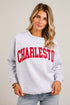 A woman wearing a light heather gray crewneck sweatshirt with &