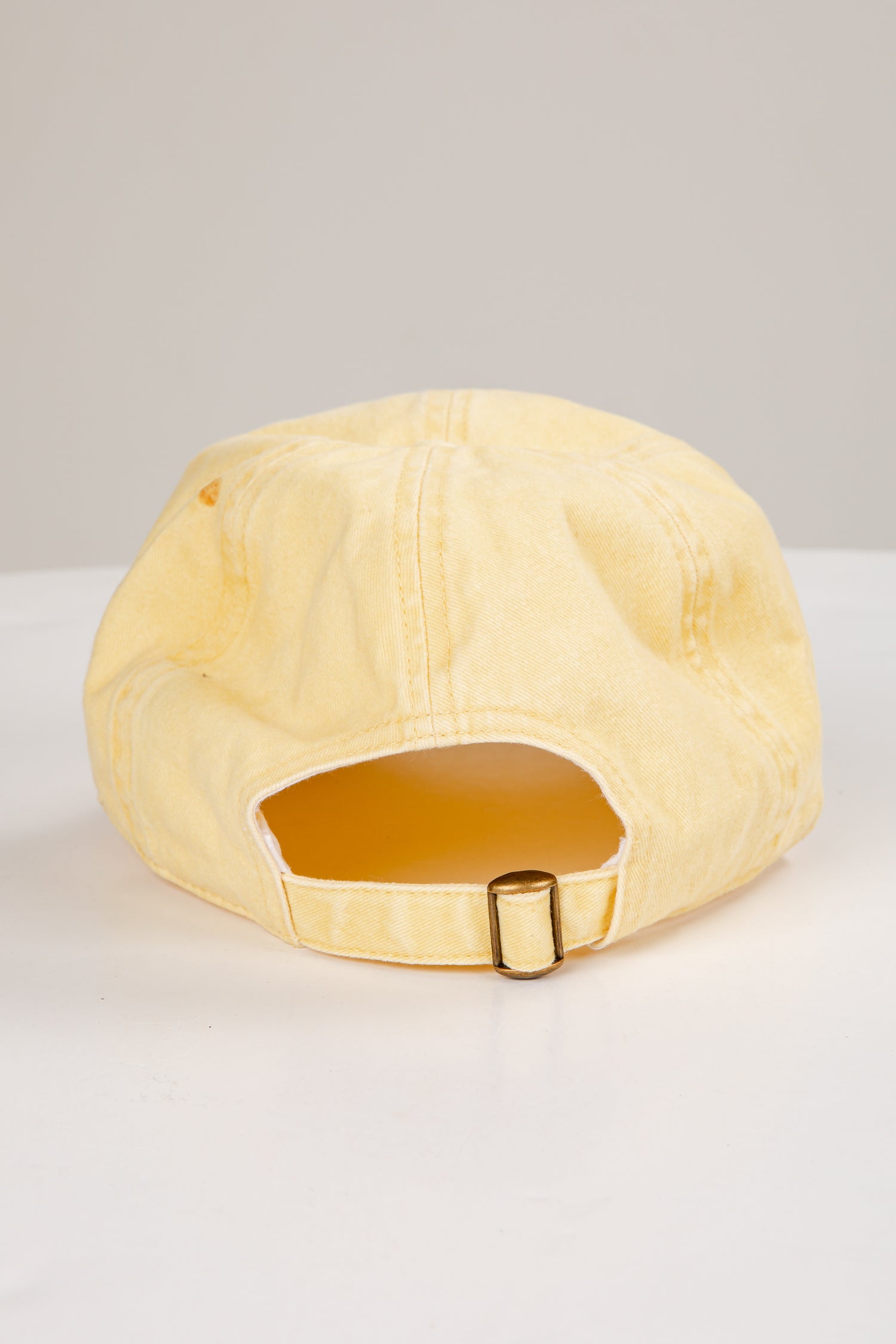 Beige cap with a gold buckle on a white background