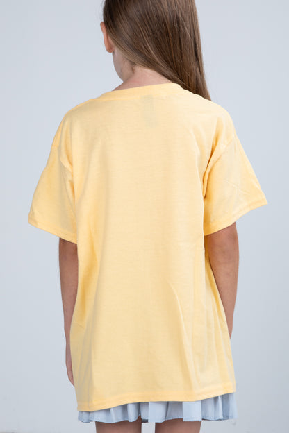 Person wearing a yellow t-shirt on a plain background