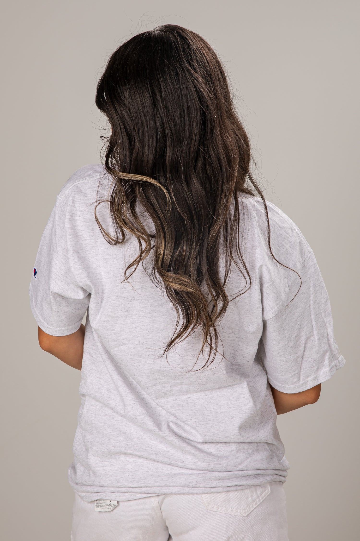 Person wearing a gray t-shirt with a plain background