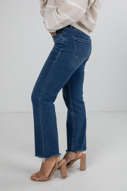 Person wearing blue jeans and a beige sweater on a white background