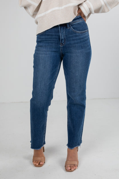 Person wearing blue jeans and a beige sweater on a white background