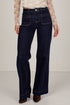 A model wearing dark blue wide-leg denim jeans with a beige lace long-sleeve top and brown suede boots, shown from the waist down against a light off-white studio background.