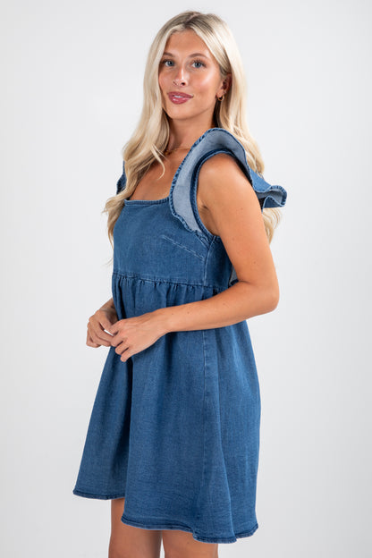 Woman wearing a blue denim dress with a white background