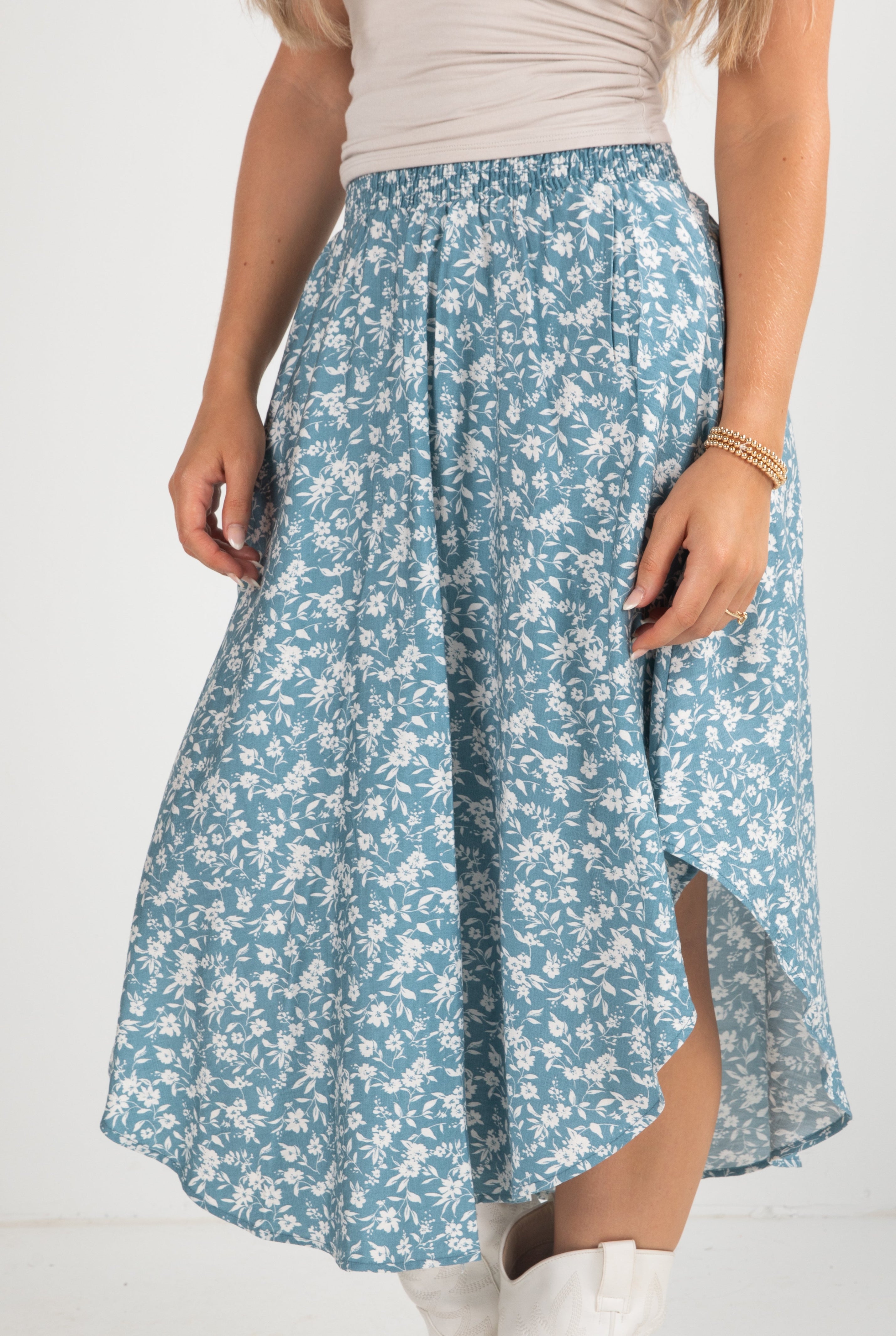 Person wearing a blue floral skirt on a white background