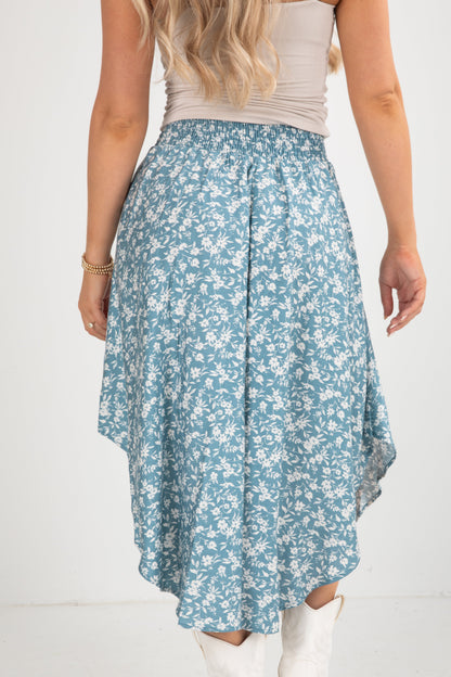 Woman wearing a blue floral skirt on a white background