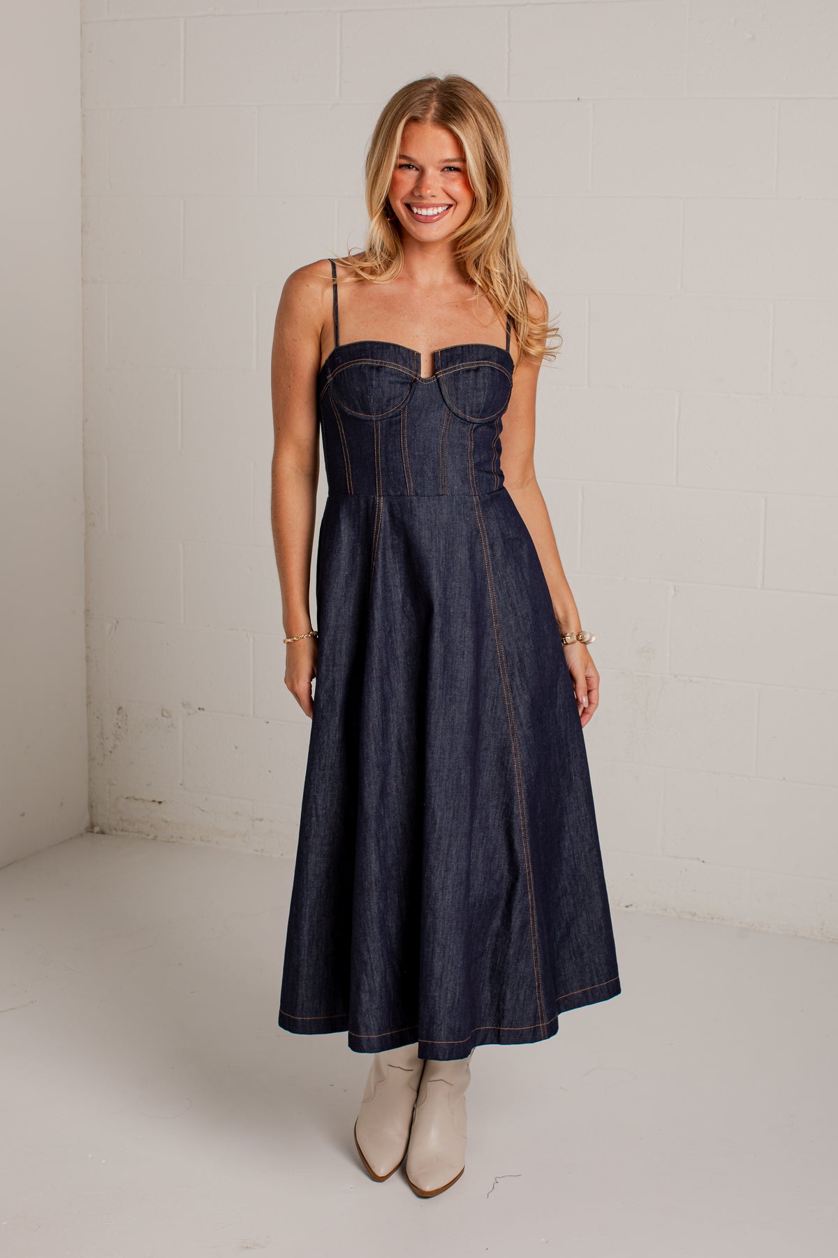 dark-wash midi dress features a strapless bustier-inspired bodice with defined seaming and a flattering fitted silhouette
