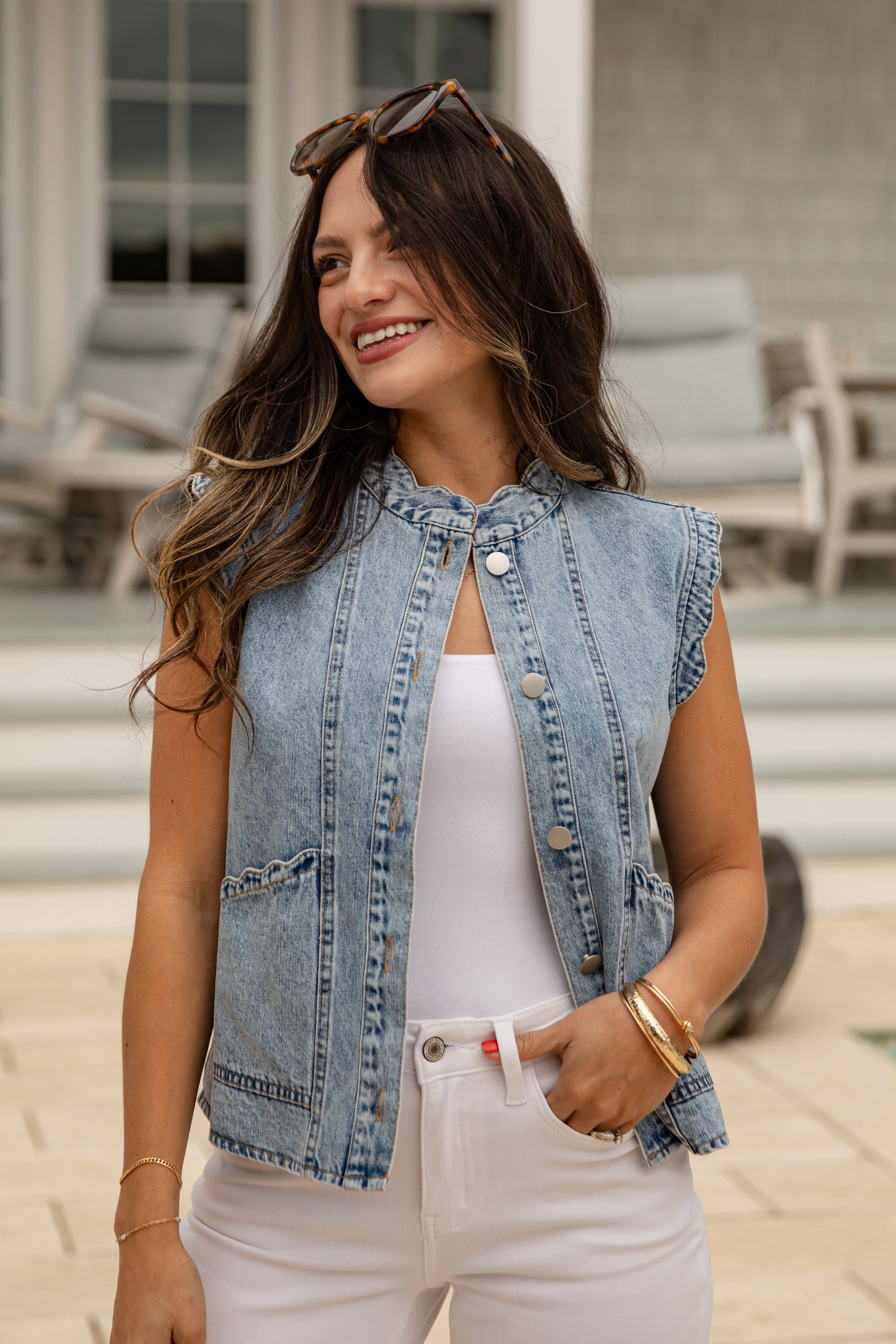Woman wearing a denim vest and white pants outdoors