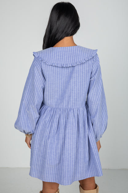 Blue and white striped dress worn by a person on a plain background