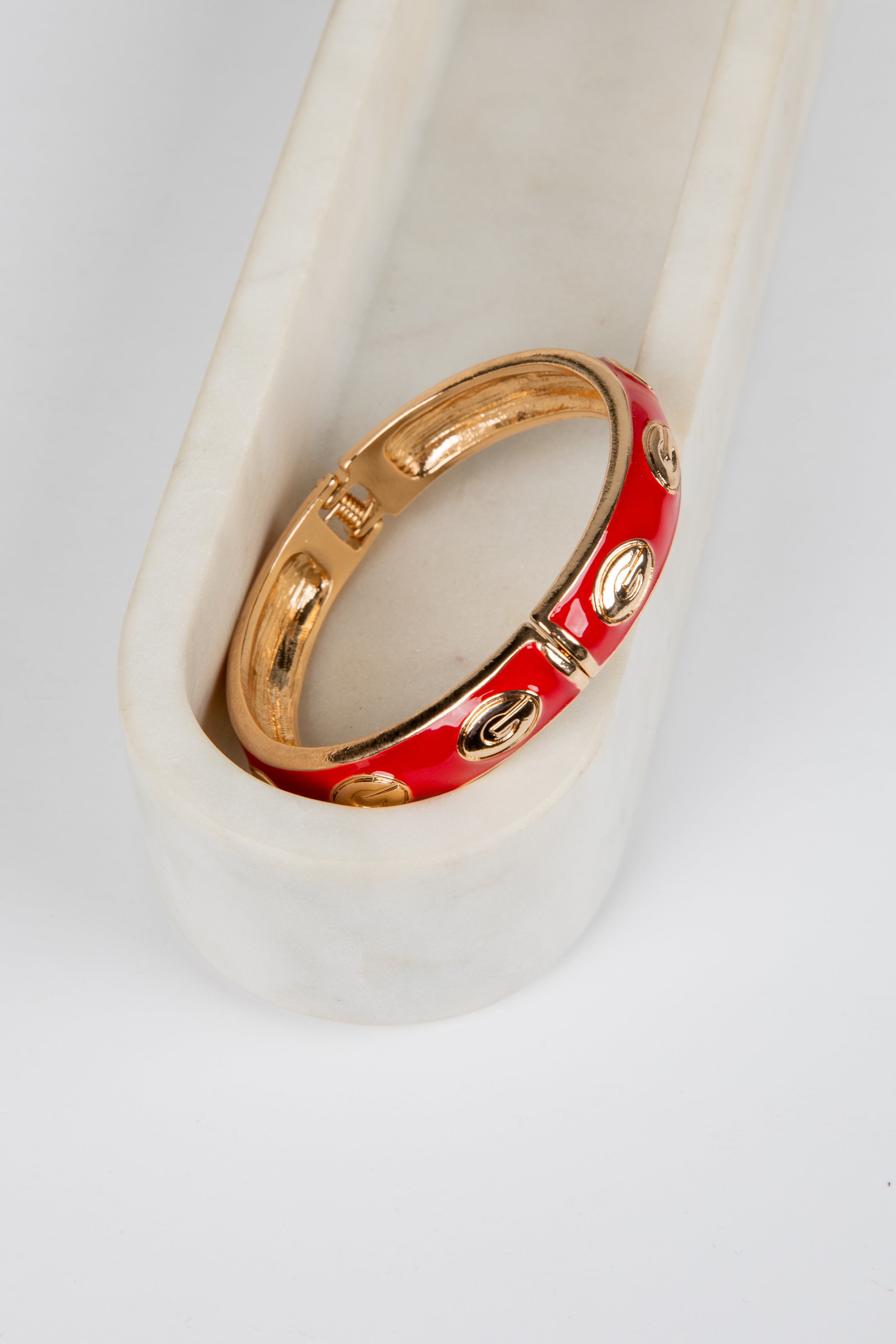 Gold and red ring on a white ceramic stand