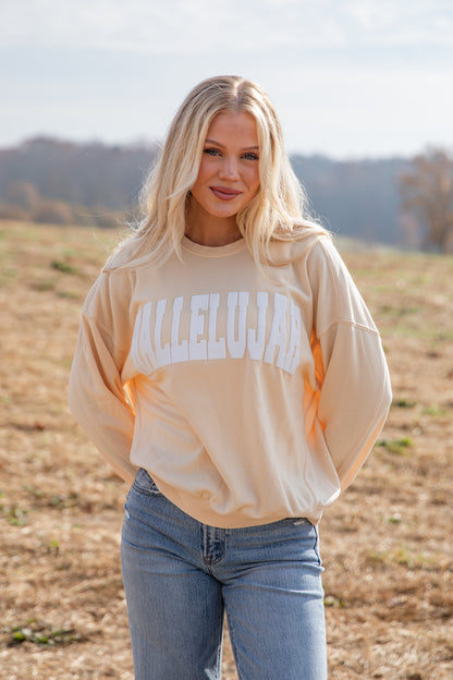 Woman wearing a beige sweatshirt with &