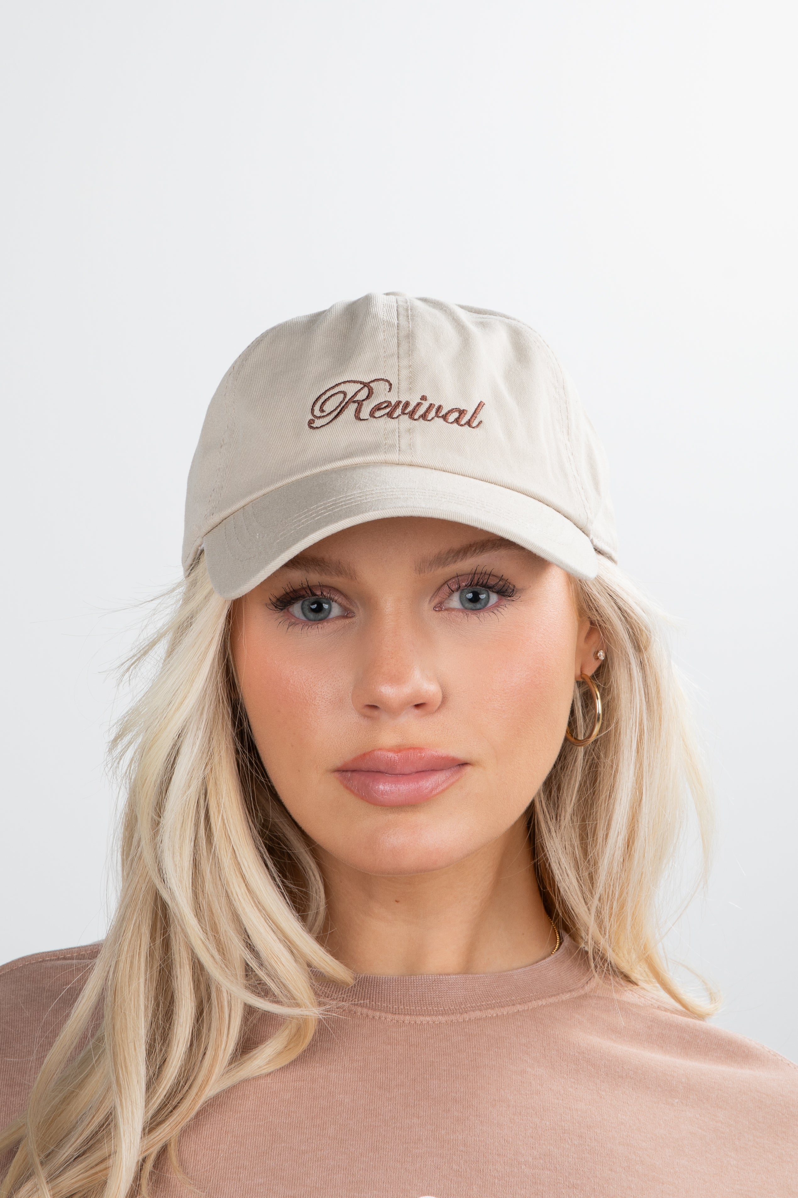Woman wearing a beige cap with &