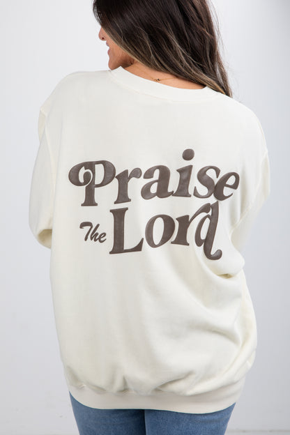 Person wearing a cream-colored sweatshirt with &