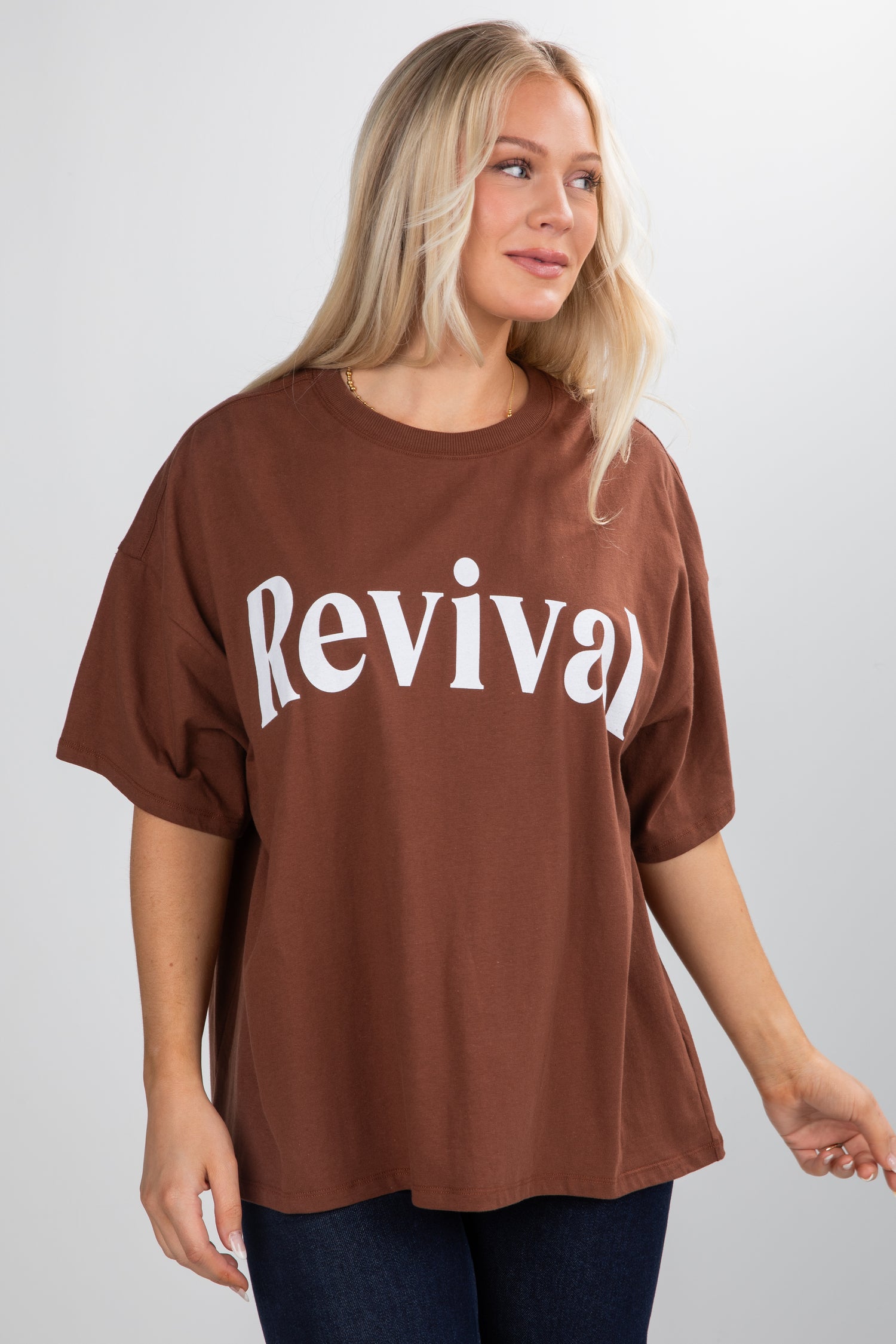 Woman wearing a brown oversized t-shirt with &