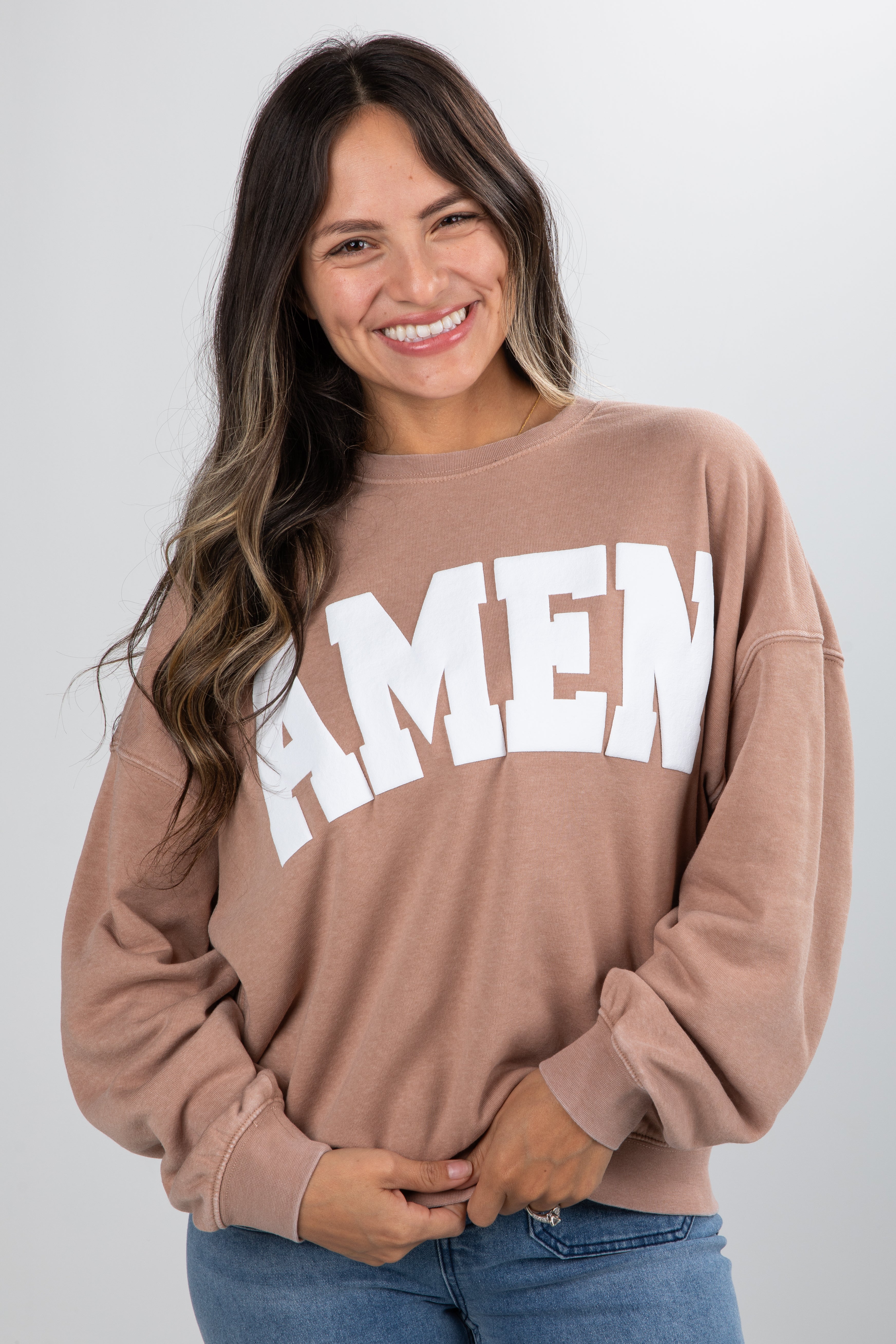 Woman wearing a brown sweatshirt with &