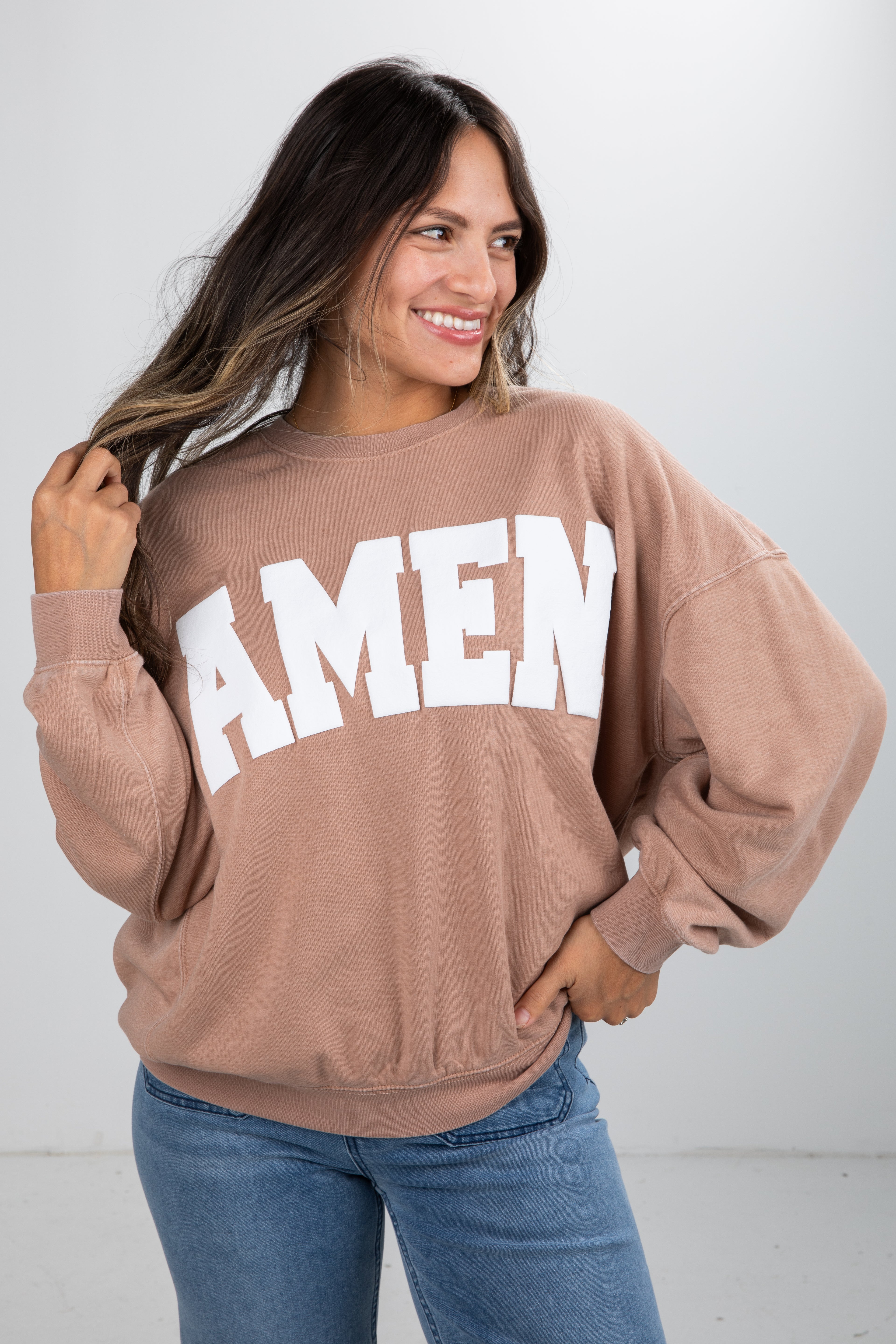 Woman wearing a brown sweatshirt with &