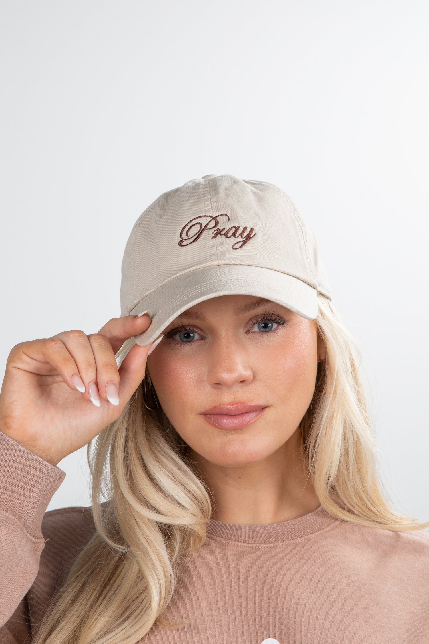 Woman wearing a beige cap with &