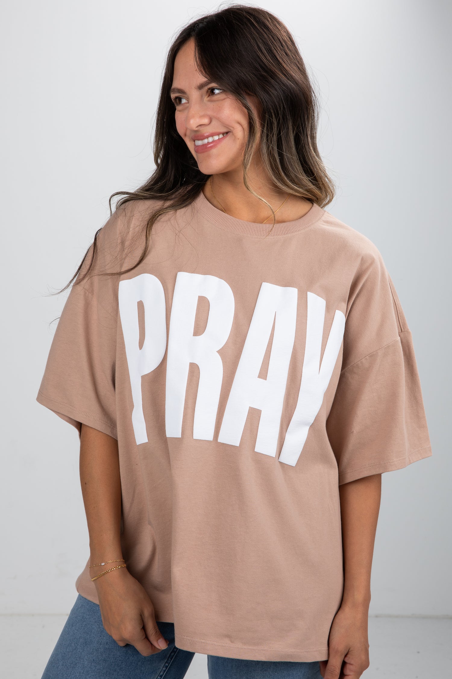 Woman wearing a beige t-shirt with &