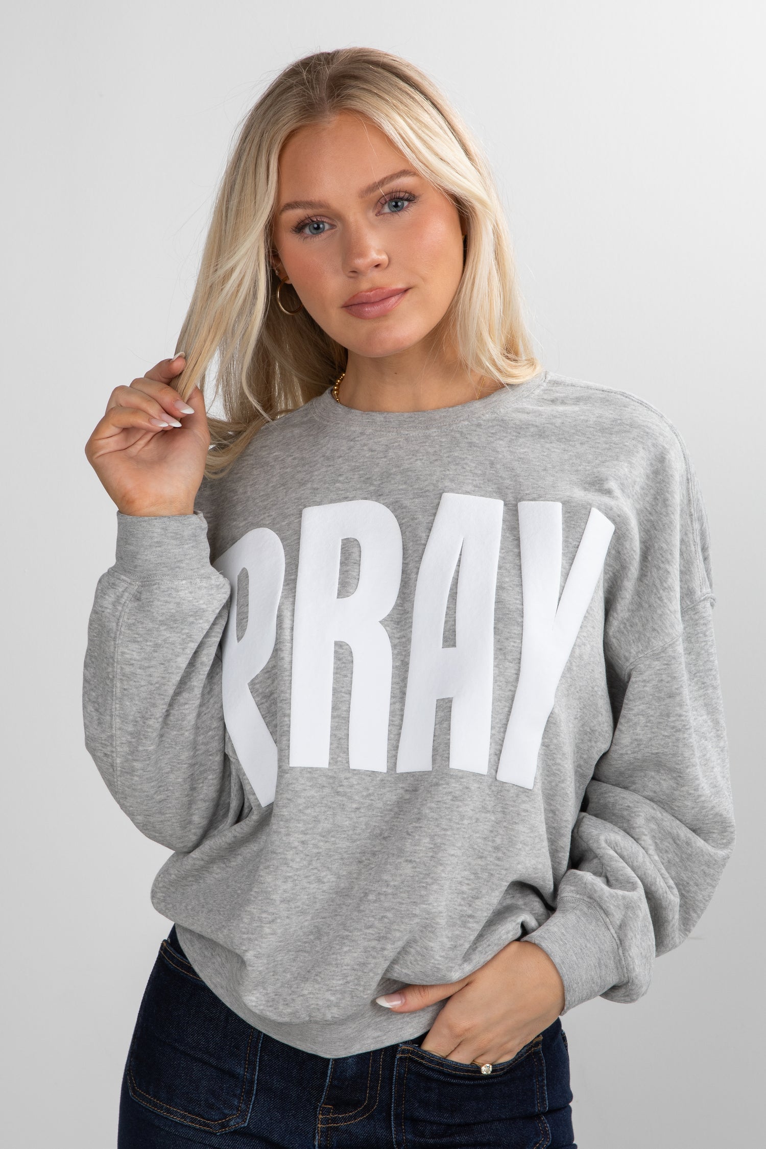Woman wearing a gray sweatshirt with &