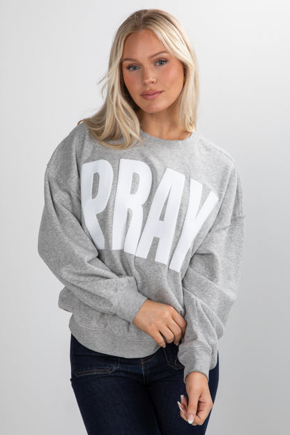 Woman wearing a gray sweatshirt with &