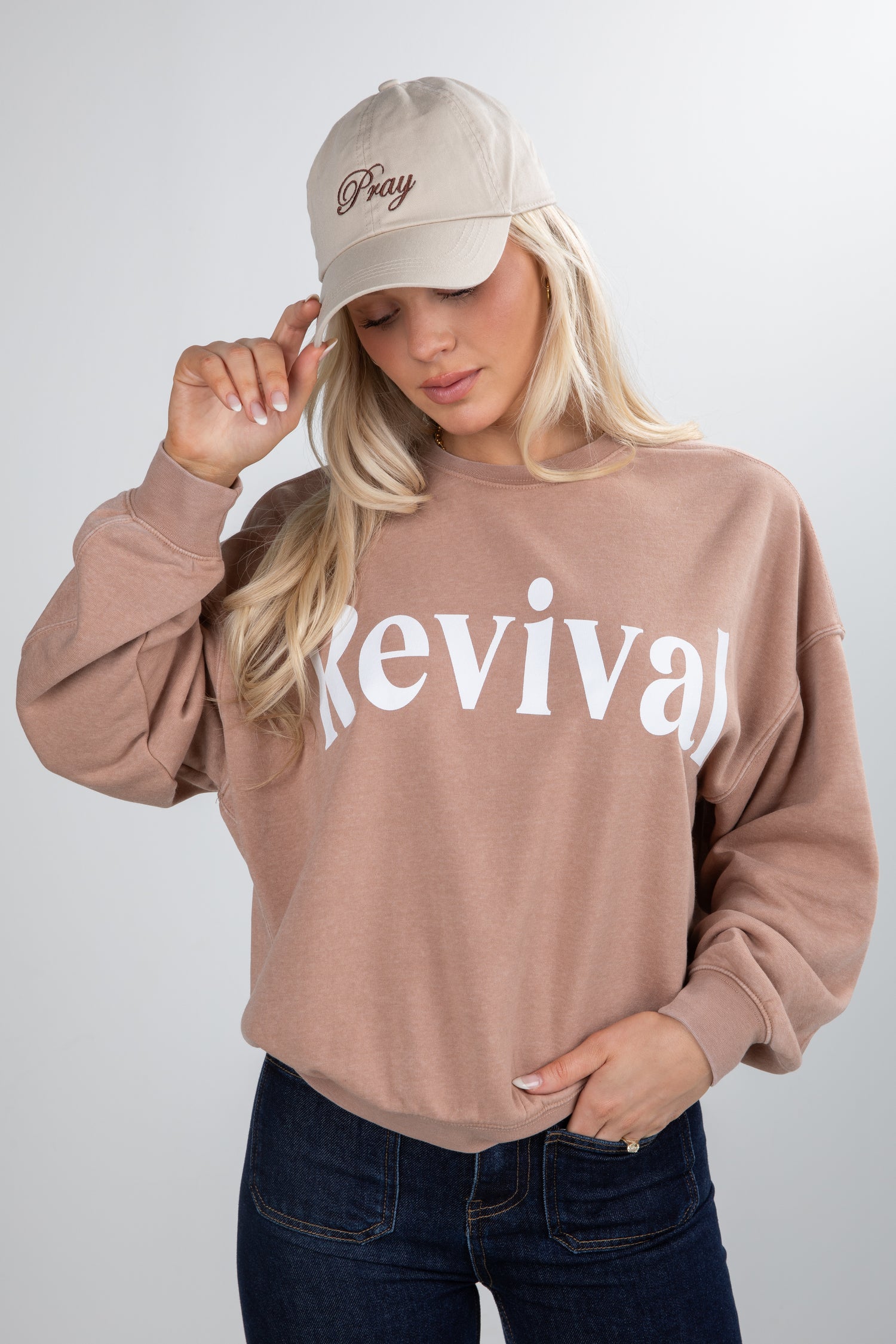 Person wearing a beige sweatshirt with &