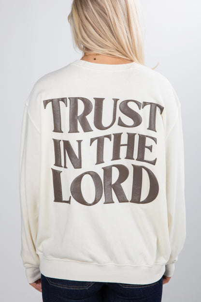 Person wearing a cream sweatshirt with &