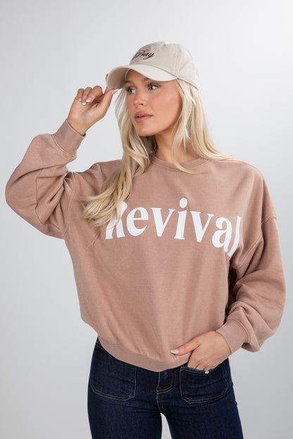 Woman wearing a beige sweatshirt with &