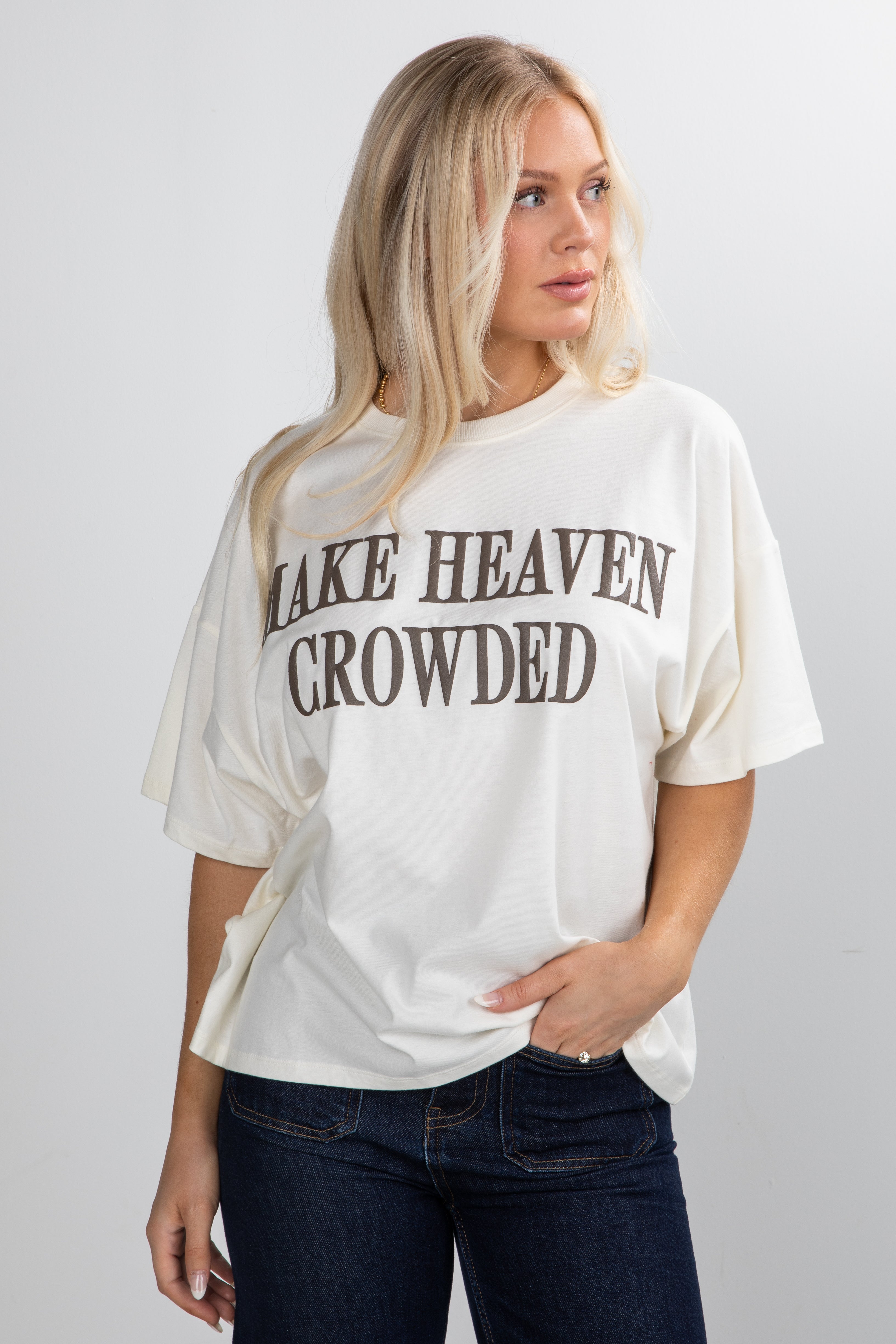 Woman wearing a white t-shirt with text on a plain background