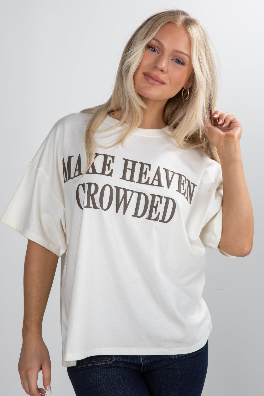 Woman wearing a white t-shirt with text on a plain background