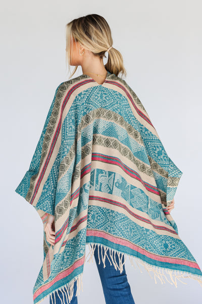 model wearing a teal fringe shawl