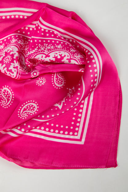 Pink bandana with white paisley pattern on a light gray background