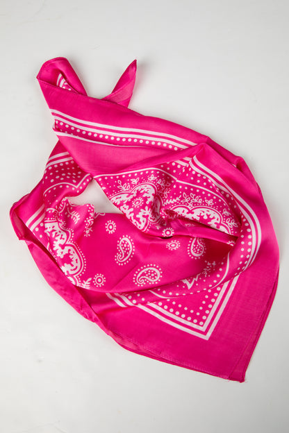 Pink bandana with white paisley pattern on a light gray background